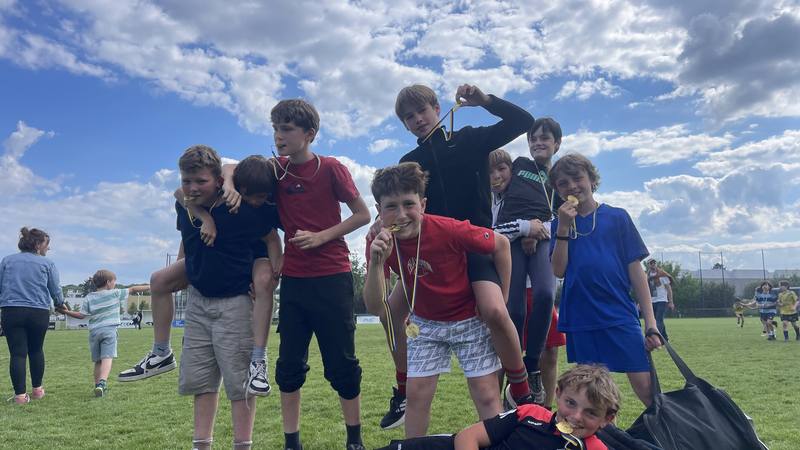 Des jeunes joueurs du club réunis sur un terrain, sous un grand ciel bleu.